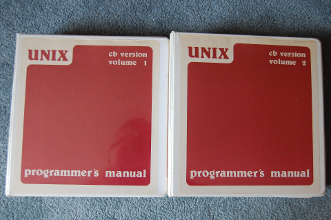 Two red books containing Volume 1 and 2 of Programmers Manuals for CB Unix