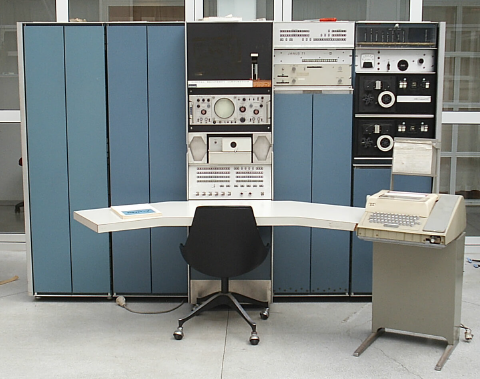 Photo of a big, old computer the size of a wardrobe. The dominating color is teal.